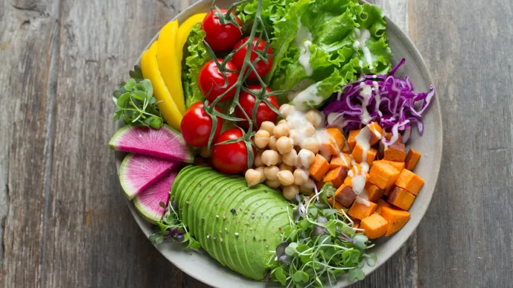 Colorful healthy foods for perimenopause diet including vegetables, salmon, berries, and nuts on a wooden table